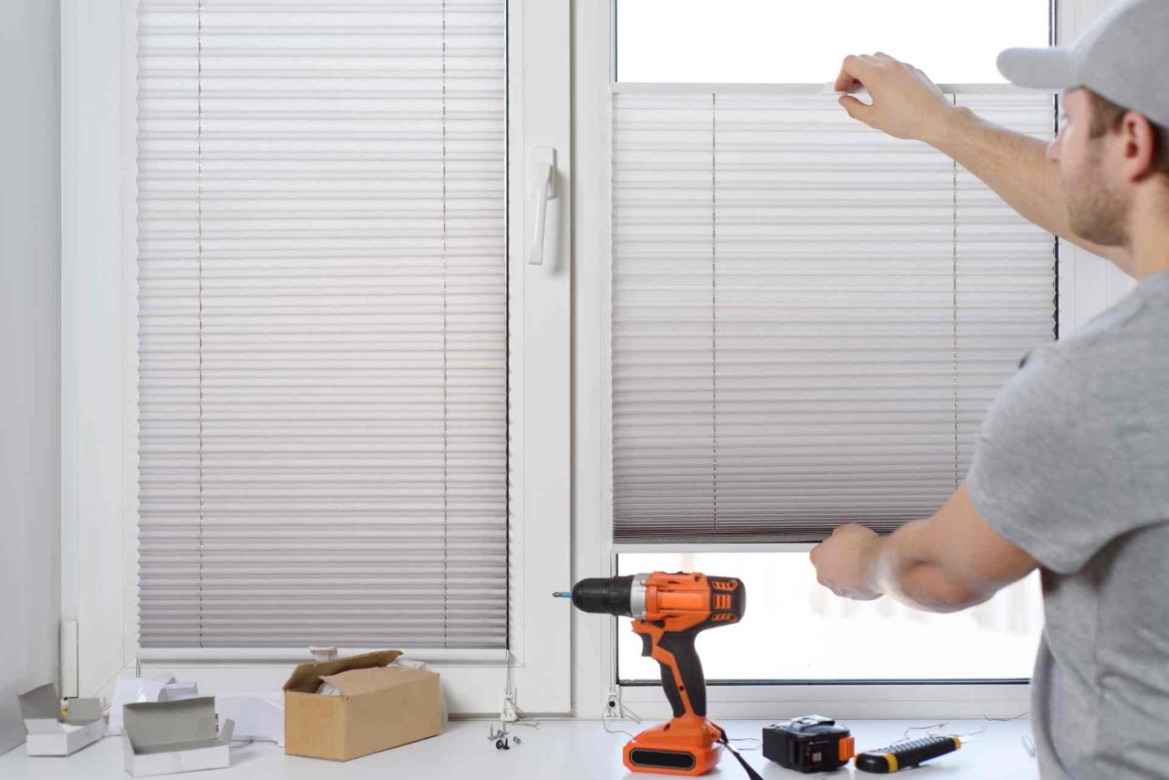 A window blind repair professional fixing aluminum blinds in a residential home using tools at All About Blinds JC near johnson city, Tennessee (TN)