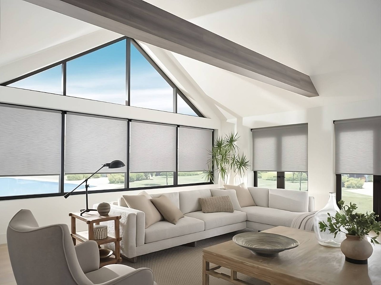 Solar Shades on large windows in an airy living room overlooking blue skies and a pool at All About Blinds near Johnson City, TN 